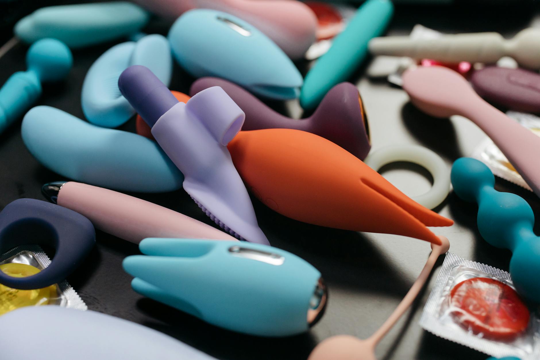 Una collezione di vibratori colorati e giocattoli per adulti in primo piano.