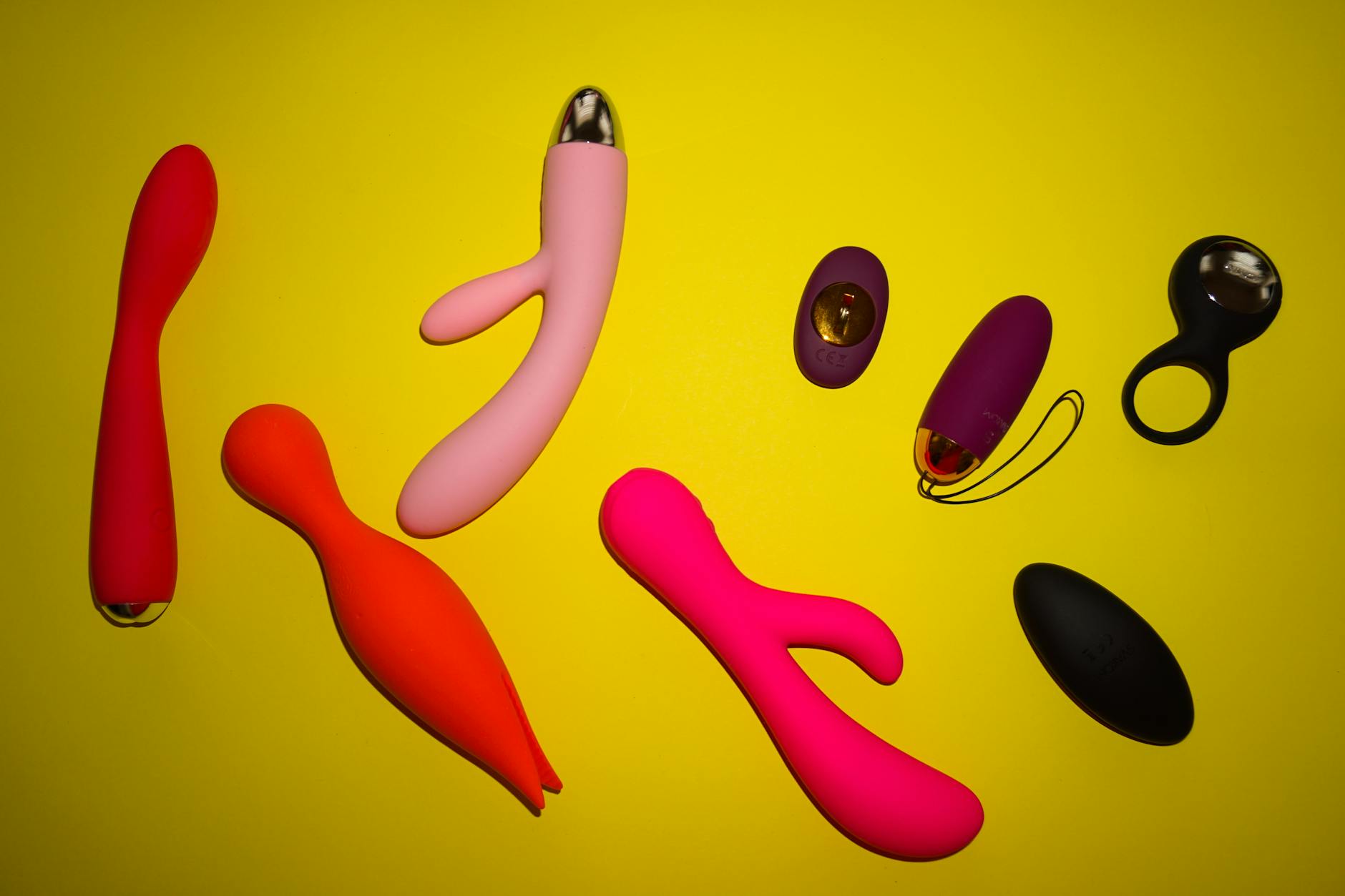 Mani che tengono vibatori in silicone dai colori pastello, simbolo di piacere e benessere sessuale